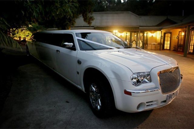 White stretch limousine waiting outside an event venue