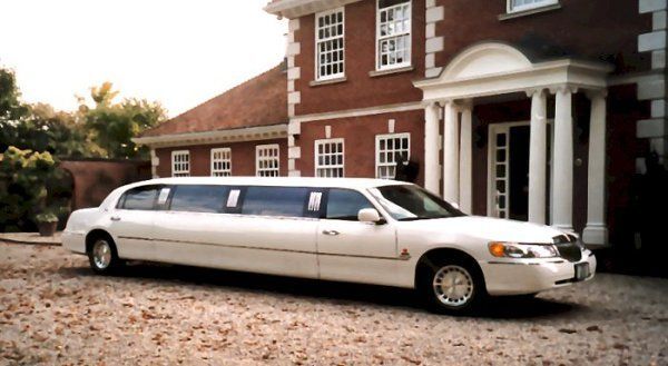 White stretch limousine waiting outside an event venue