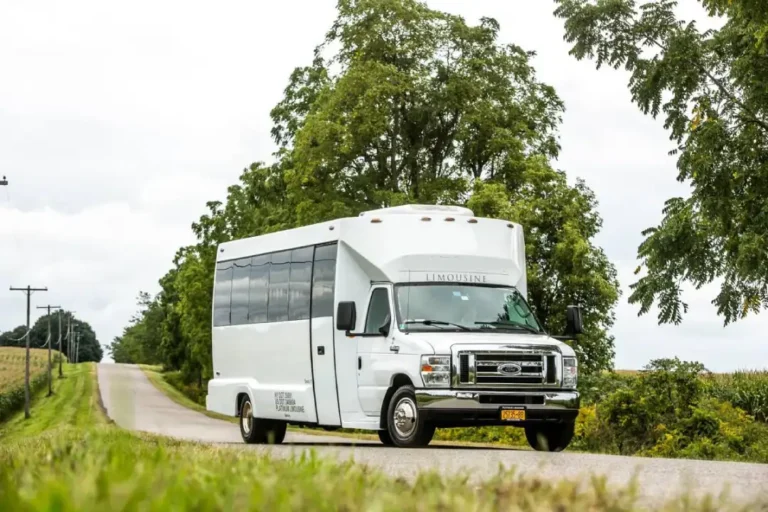 White limo party bus travelling on a rural road